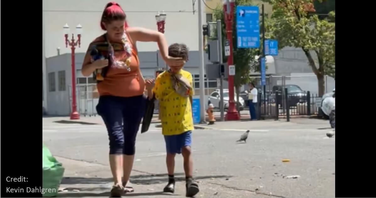 Typical scene: Mother shields child’s eyes from drug addicts